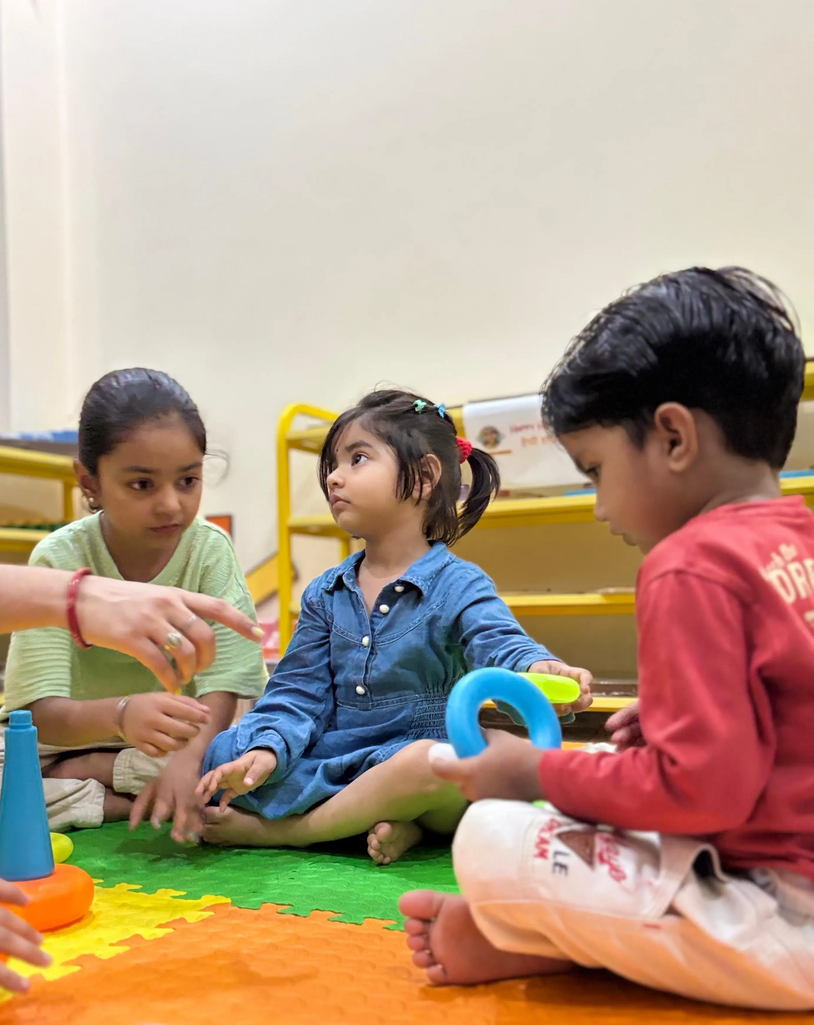 Happy children playing with building blocks in a colorful classroom